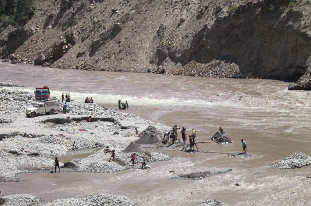 Nepali workers harvesting sand from beside and in the river
