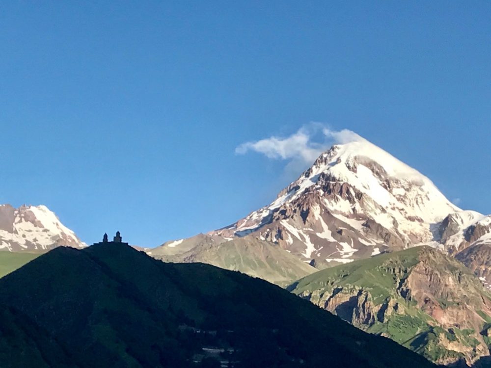 The clock tower and Gergeti church in silhouette alongside Kazbek. It is rated high in the list of beautiful churches, aided by its spectacular location. In times of invasion national treasures were kept in there, because of its difficult access