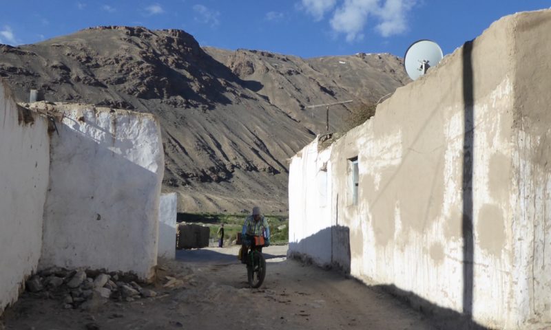 Cycling they the white washed walls of village houses