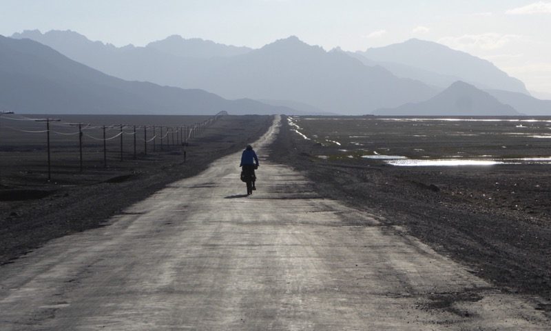 Cyclist on the road, being blown to Murghab
