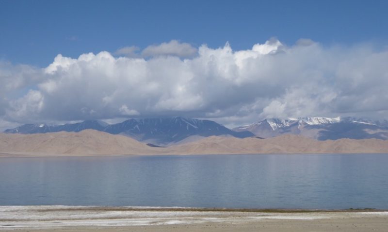 The azure blue of Kara Kul is from salt, the lake bed was created by a meteorite and had no outlet